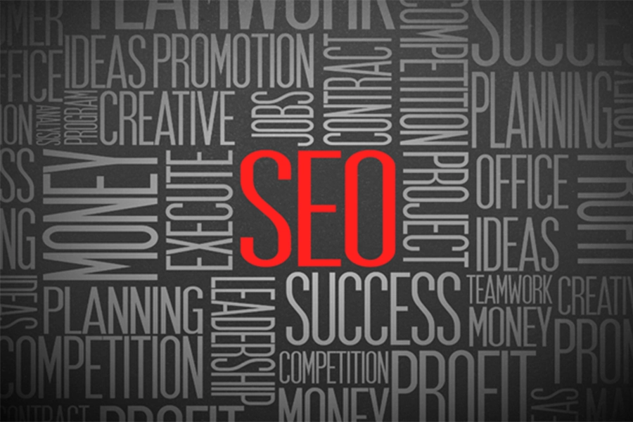 This is a picture of the acronym SEO in red letters with a gray background surrounded by other words.